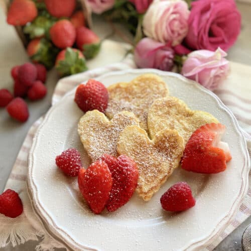 Top view of heart pancakes on a white plate with heart shaped pancakes.