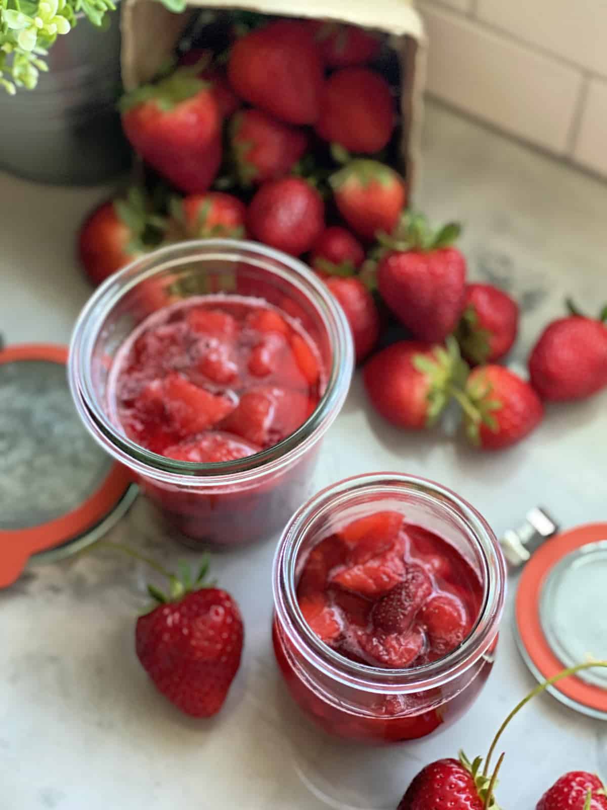 Top view of strawberry sauce in two glass jars.
