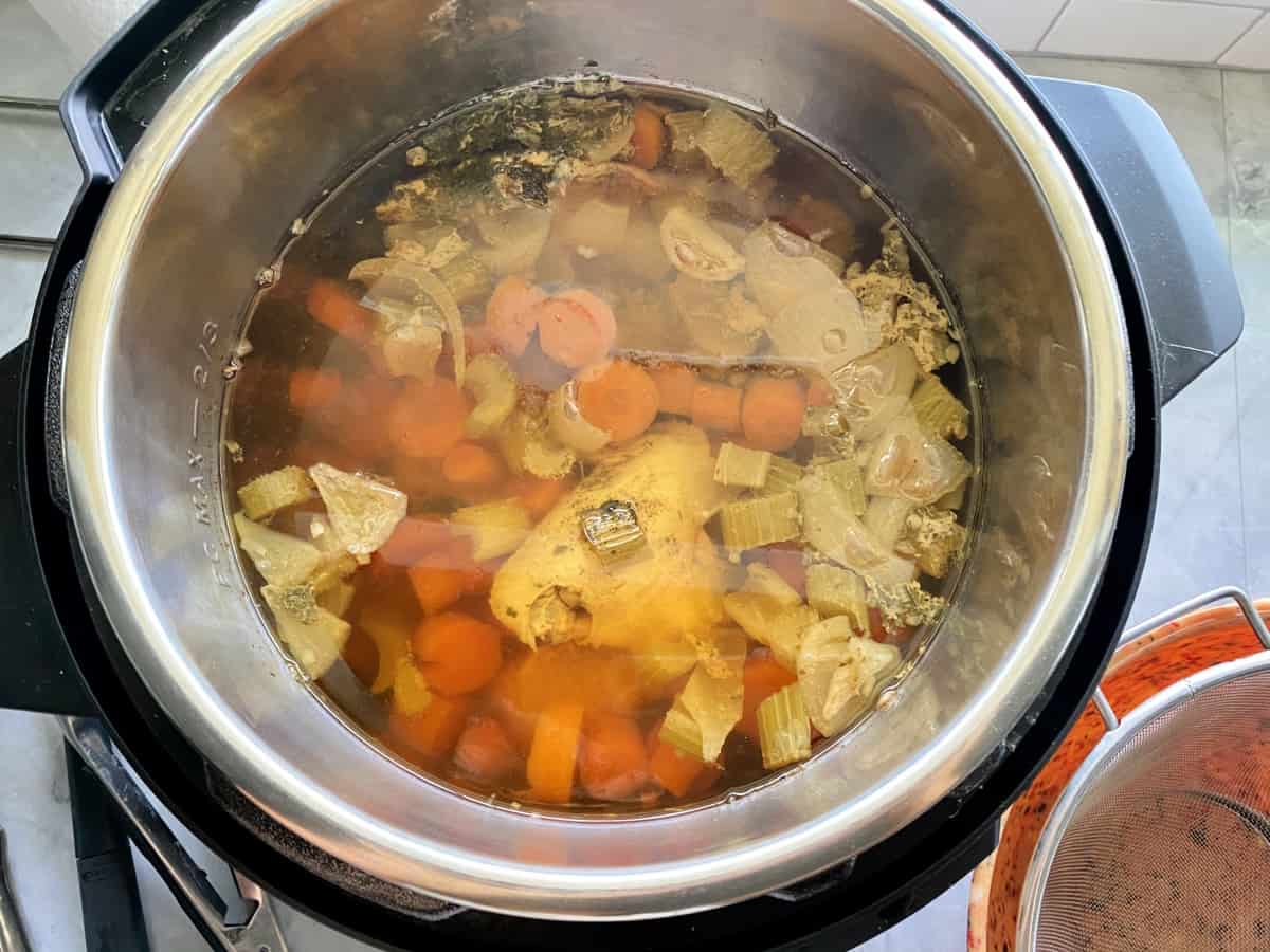 Top view of an Instant Pot with cooked carrots, celery, and chicken.