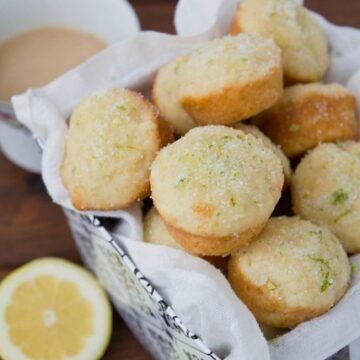 Tin basket lined with white cloth filled with mini muffins.