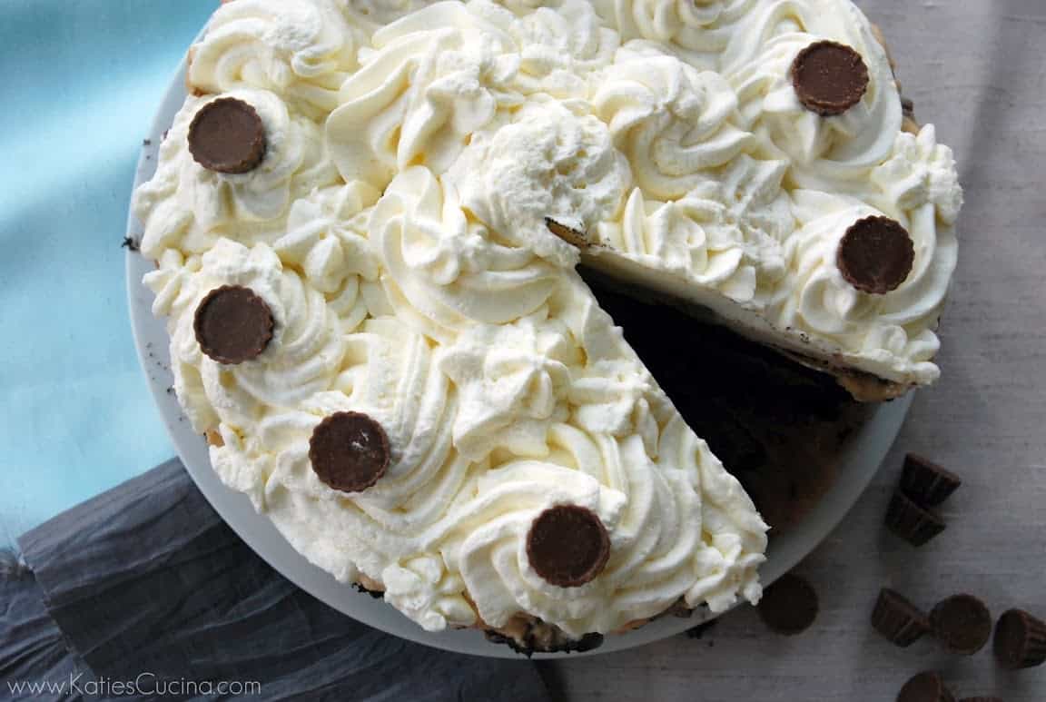 Top view of a piped white cake with a slice cut out of it.