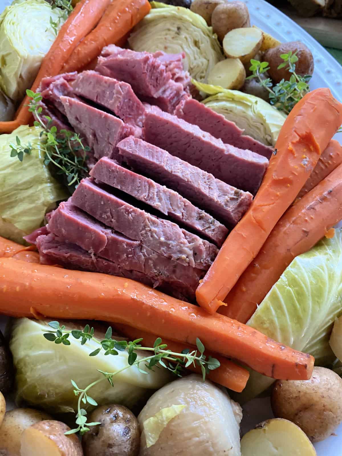 Close up of a platter of beef, carrots, cabbage, and potatoes.