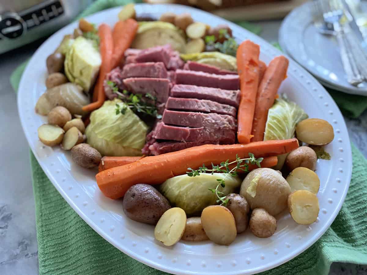White platter filled with potatoes, carrots, corned beef, and cabbage.