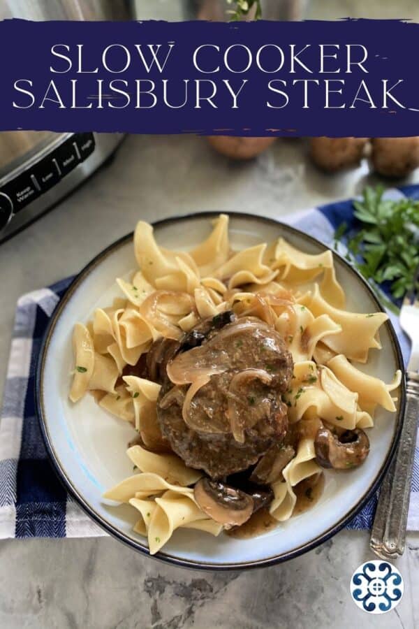 Top view of a white plate filled with egg noodles, and ground beef steak with onion gravy with text on image.