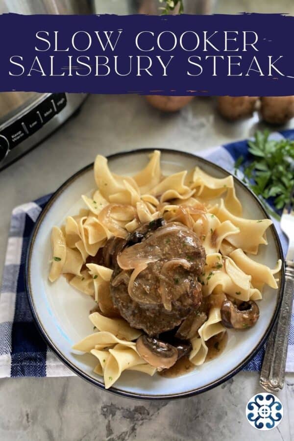 Top view of a white plate filled with egg noodles, and ground beef steak with onion gravy with text on image.