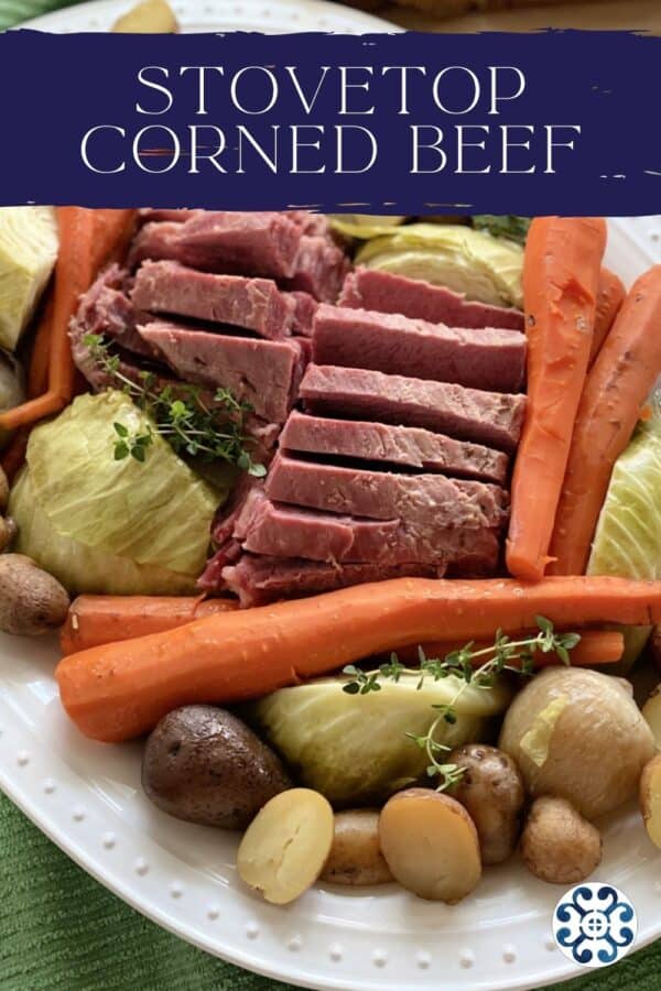 Close up of a platter of corned beef and cabbage with carrots and potatoes with text on top for Pinterest.