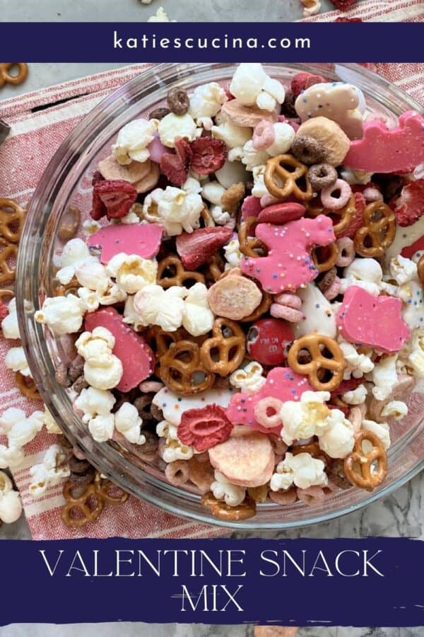 Top view of a glass bowl filled with popcorn, animal crackers, and strawberries with text on image for Pinterest.