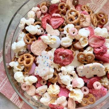 Top view of a glass bowl filled with various red, pink, and white snacks.