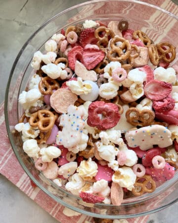 Top view of a glass bowl filled with various red, pink, and white snacks.