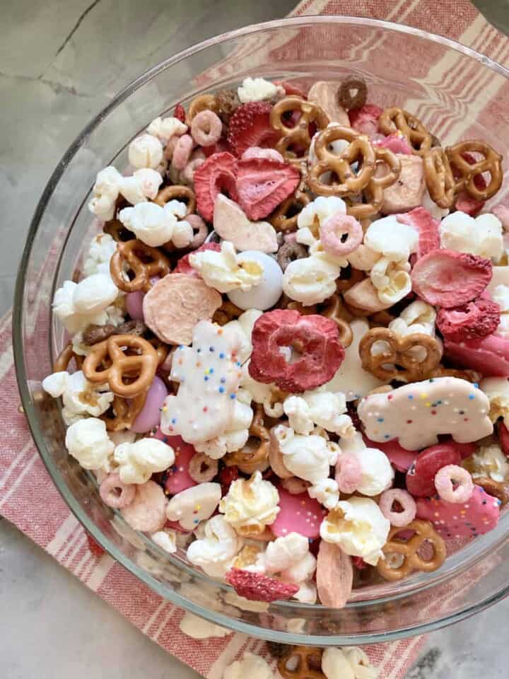 Top view of a glass bowl filled with various red, pink, and white snacks.