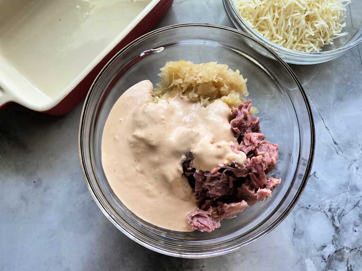 Top view of a bowl of Russian sauce, corned beef and saurkraut.