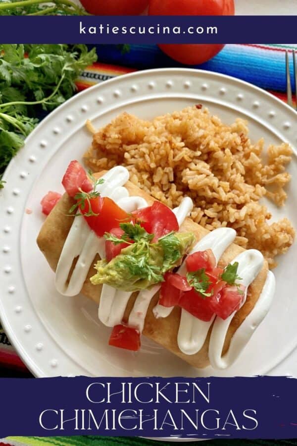 Top view of a Chicken Chimichanga with sour cream and toppings on a white plate with text on image for Pinterest.