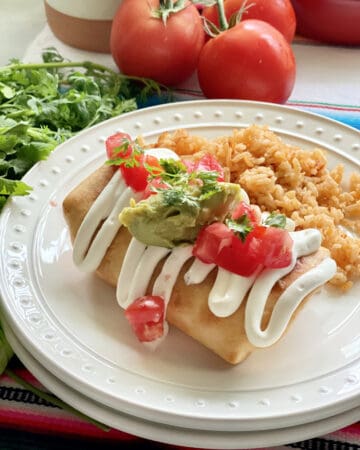 Fried Chicken Chimichanga on a white plate next to rice.