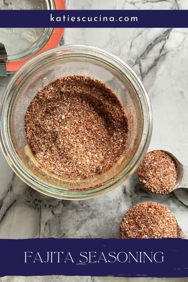 Top view of glass jar and measuring spoons filled with seasoning with text on image for Pinterest.