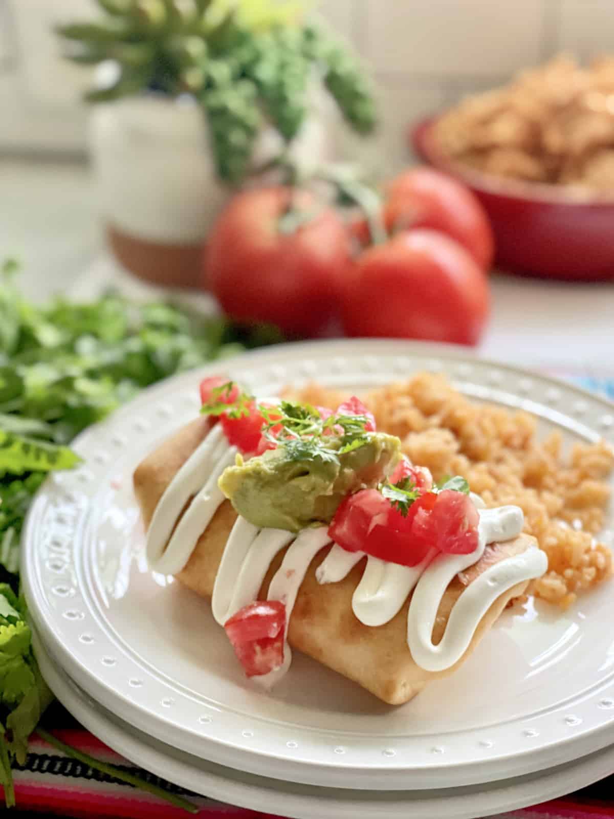 Fried Chicken Chimichanga burrito on a plate next to rice.