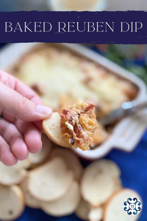 Top view of a female hand holding baguette with dip with text on image for Pinterest.