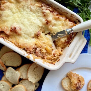 Top view of a baking dish filled with Hot Reuben Dip with a knife in the dip.