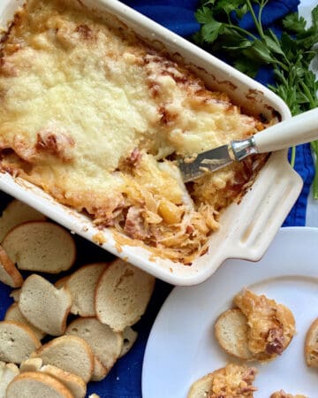 Top view of a baking dish filled with Hot Reuben Dip with a knife in the dip.