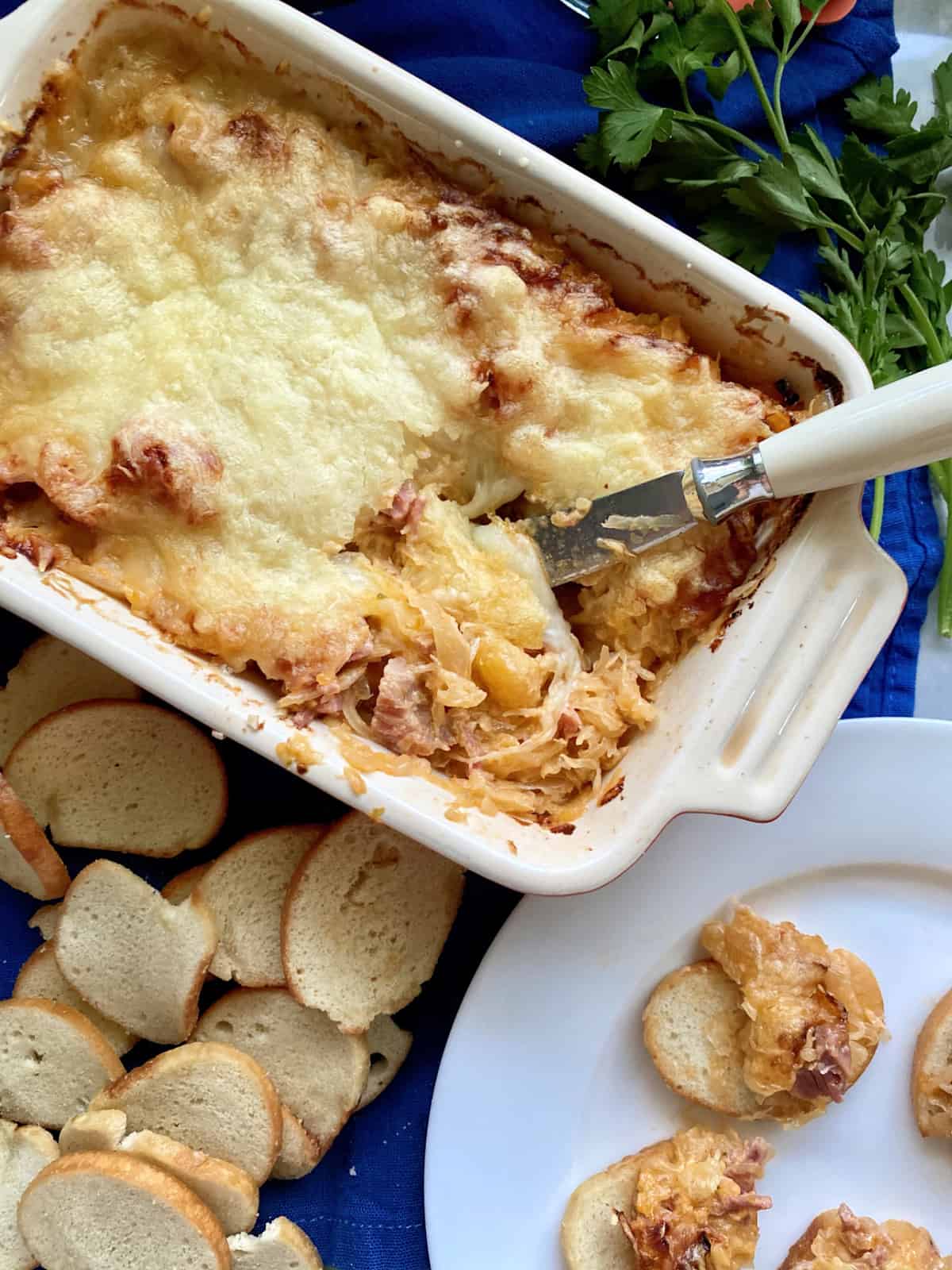 Top view of a baking dish filled with Hot Reuben Dip with a knife in the dip.