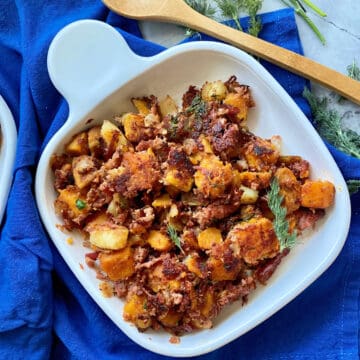 Top view of a white square plate full of Sweet Potato Corned Beef Hash on a colbalt blue cloth.