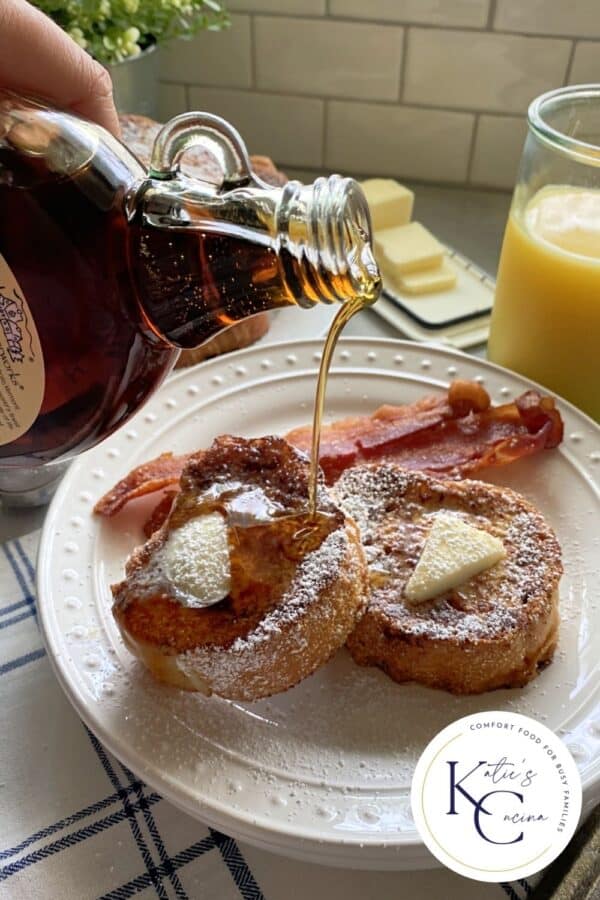 Hand pouring syrup on french toast with butter and logo on right corner.
