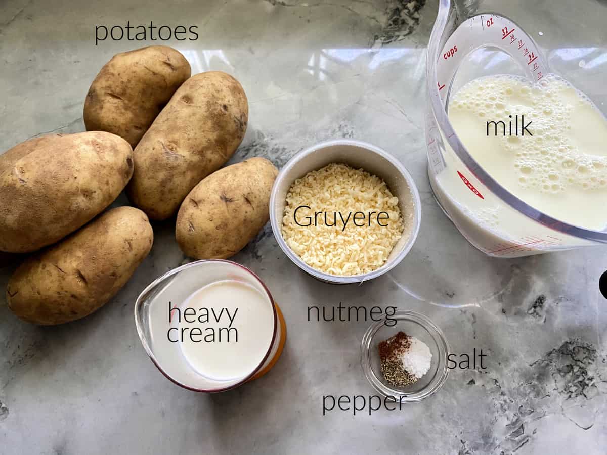 Gratin Dauphinois Ingredients: potatoes, heavy cream, gruyere cheese, nutmeg, salt, pepper, and milk