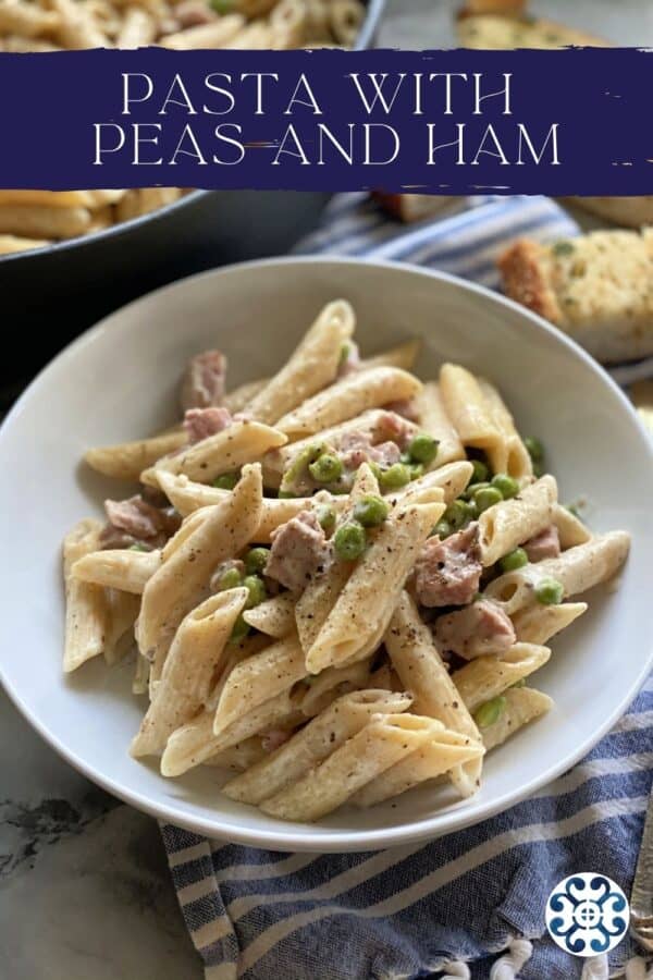 White bowl filled with penne pasta, ham, peas and black pepper with text on image for pinterest.