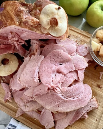 Wood cutting board with slices of ham.