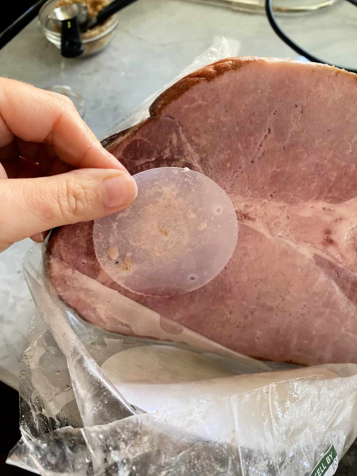 Plastic clear disc being removed from the core of the ham.