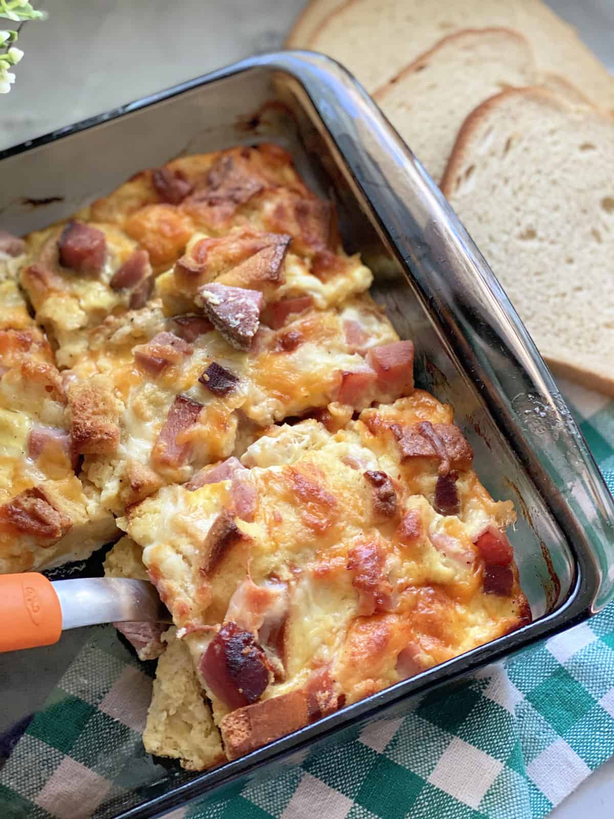 Top view of a square glass baking dish filled with an egg and ham bake.