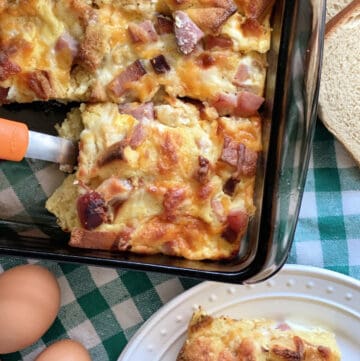 Top view of a brown baking dish with cut pieces of an egg casserole.