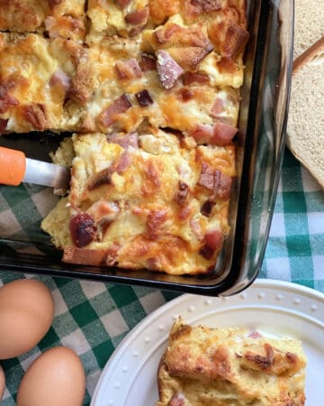 Top view of a brown baking dish with cut pieces of an egg casserole.