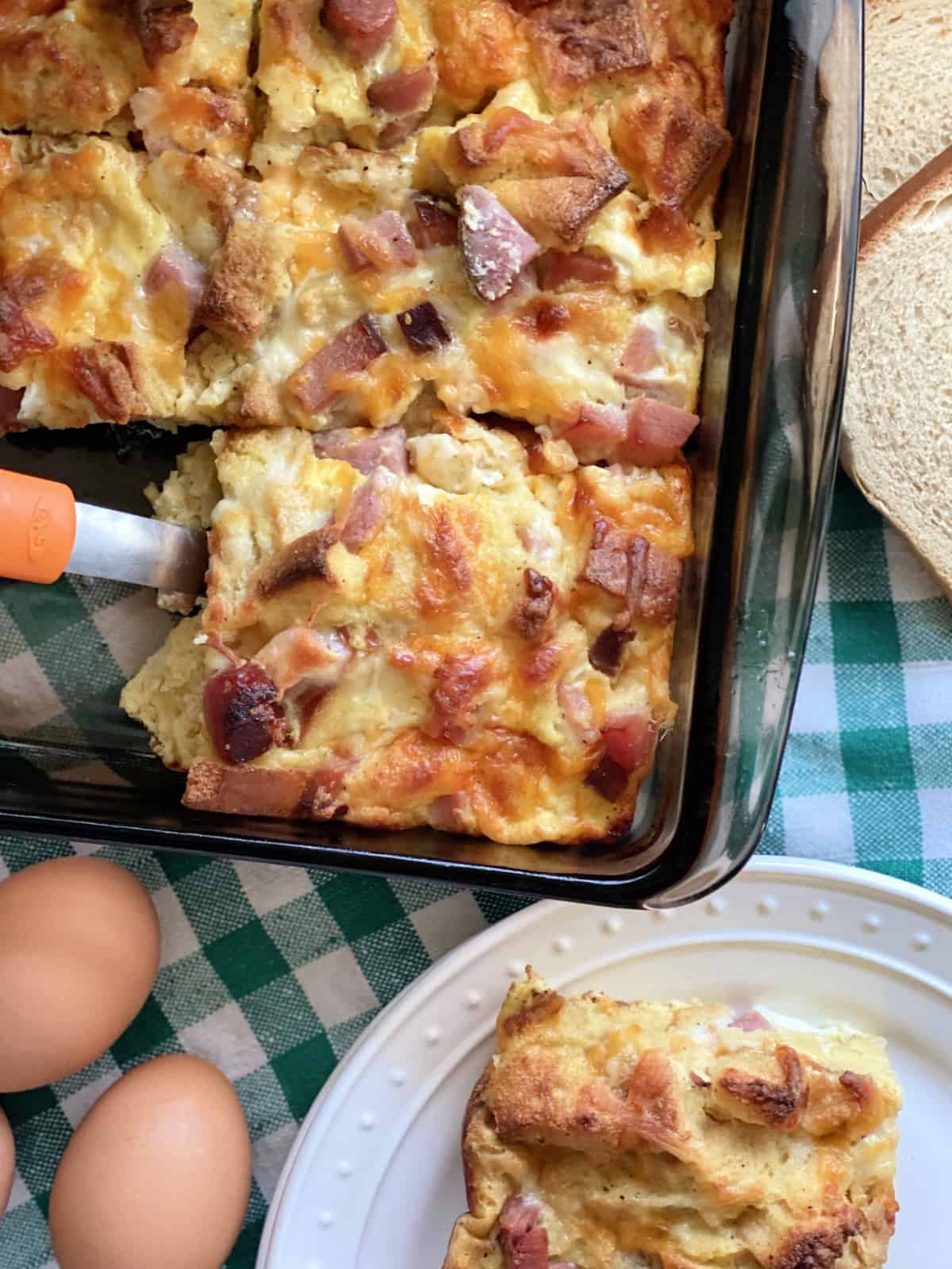 Top view of a brown baking dish with cut pieces of an egg casserole.