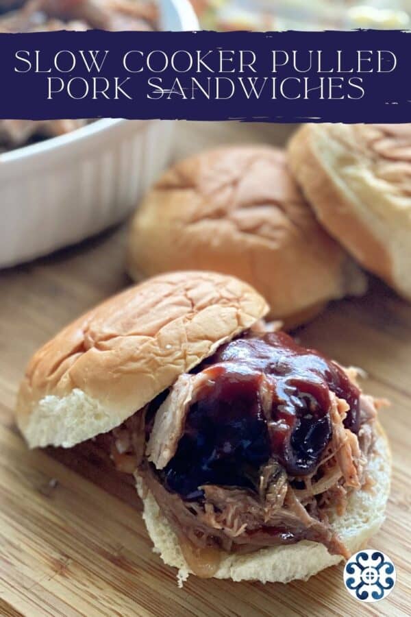 Close up of a pulled pork sandwich on a cutting board with recipe title text on image.
