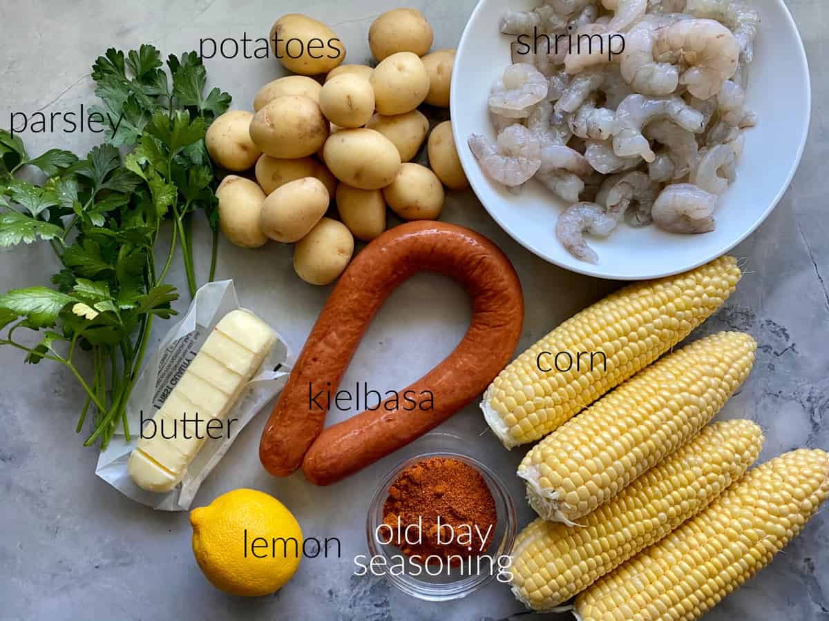 Ingredients: parsley, potatoes, shrimp, butter, kielbasa, corn, old bay seasonning, and lemon.