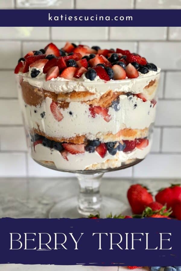 Glass bowl filled with Berry Trifle on a marble countertop with recipe title text on image.