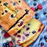 Top view of a Berry Cornmeal Pound Cake with three slices resting on a blue and white checkered cloth.