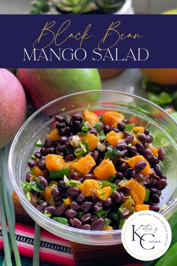 Glass bowl filled with black beans, mango, and green onion with recipe title text on image for Pinterest.