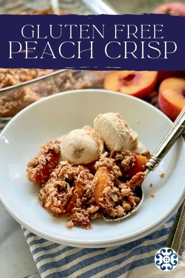 White shallow bowl filled with caramel ice cream, peach crisp, and spoon with peaches in background and recipe title text on image for Pinterest.