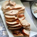 Top view of sliced turkey breast on a white platter.