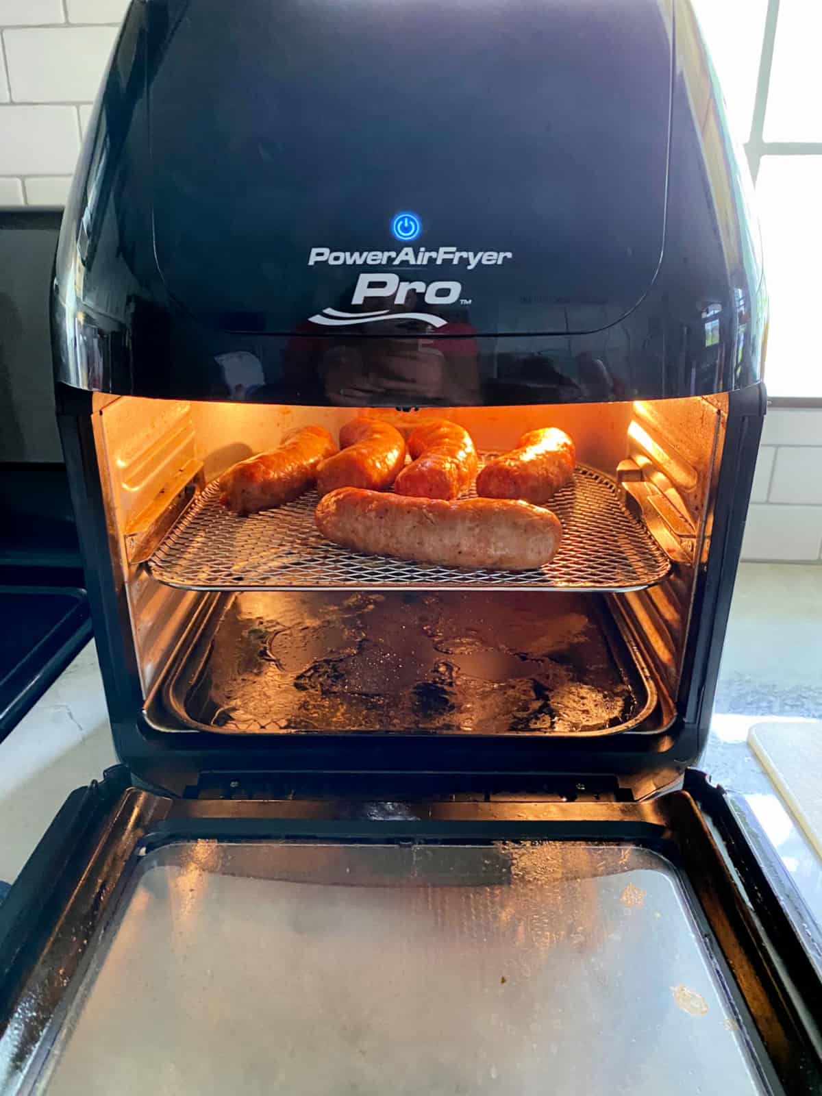 Power Air Fryer Pro with a wire rack full of sausage links inside the oven.