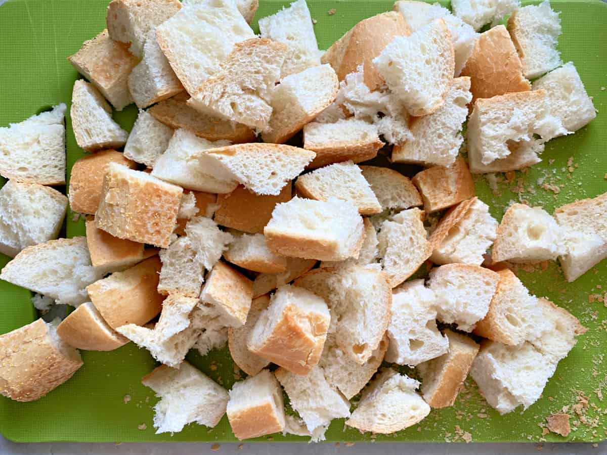 Cubed bread on a green cutting board.