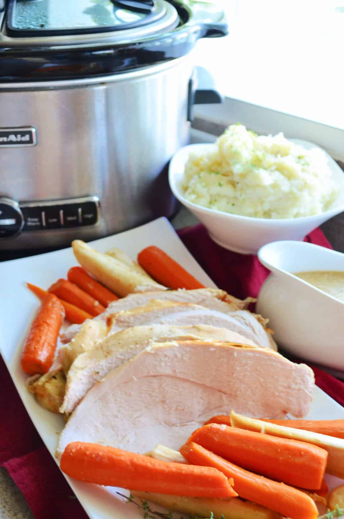 White platter filled with sliced turkey and carrots.