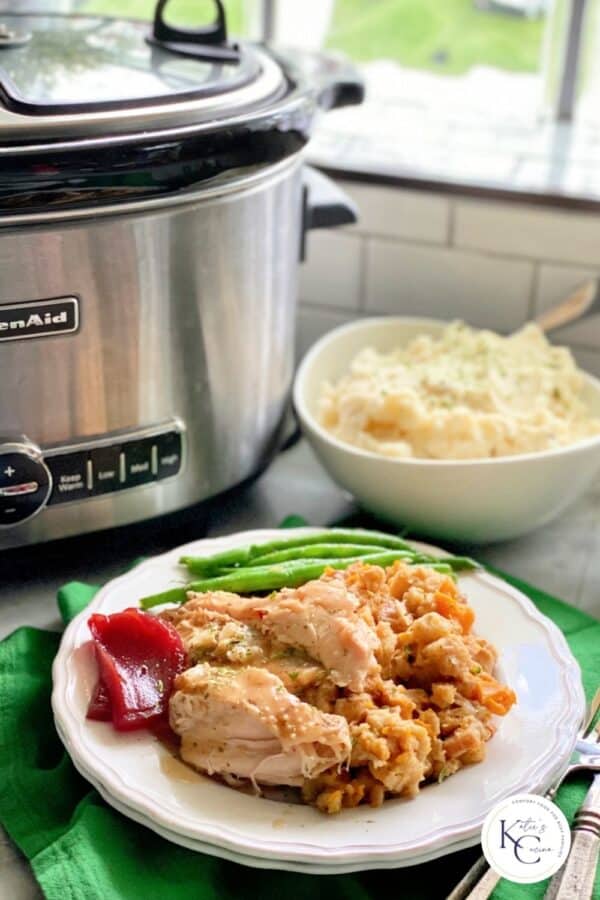 White plate sliced with turkey, stuffing, and green beans.