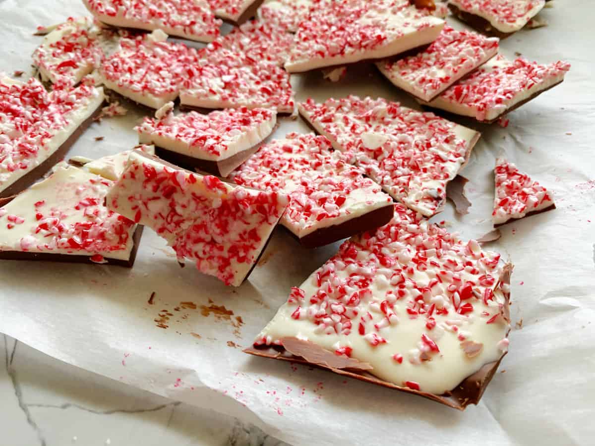 Chopped pieces of Peppermint Bark on white parchment paper.