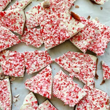 Top view of chopped pieces of peppermint bark on white parchment.
