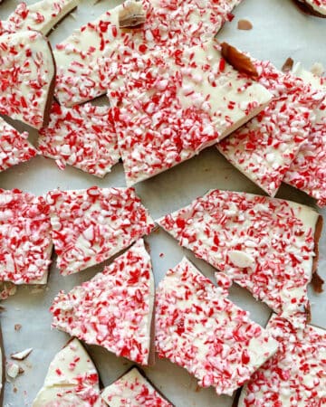 Top view of chopped pieces of peppermint bark on white parchment.