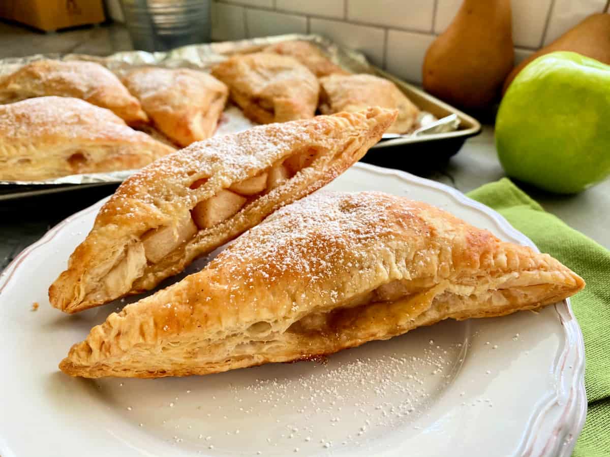 Close up of two triangle turnovers on a white plate.