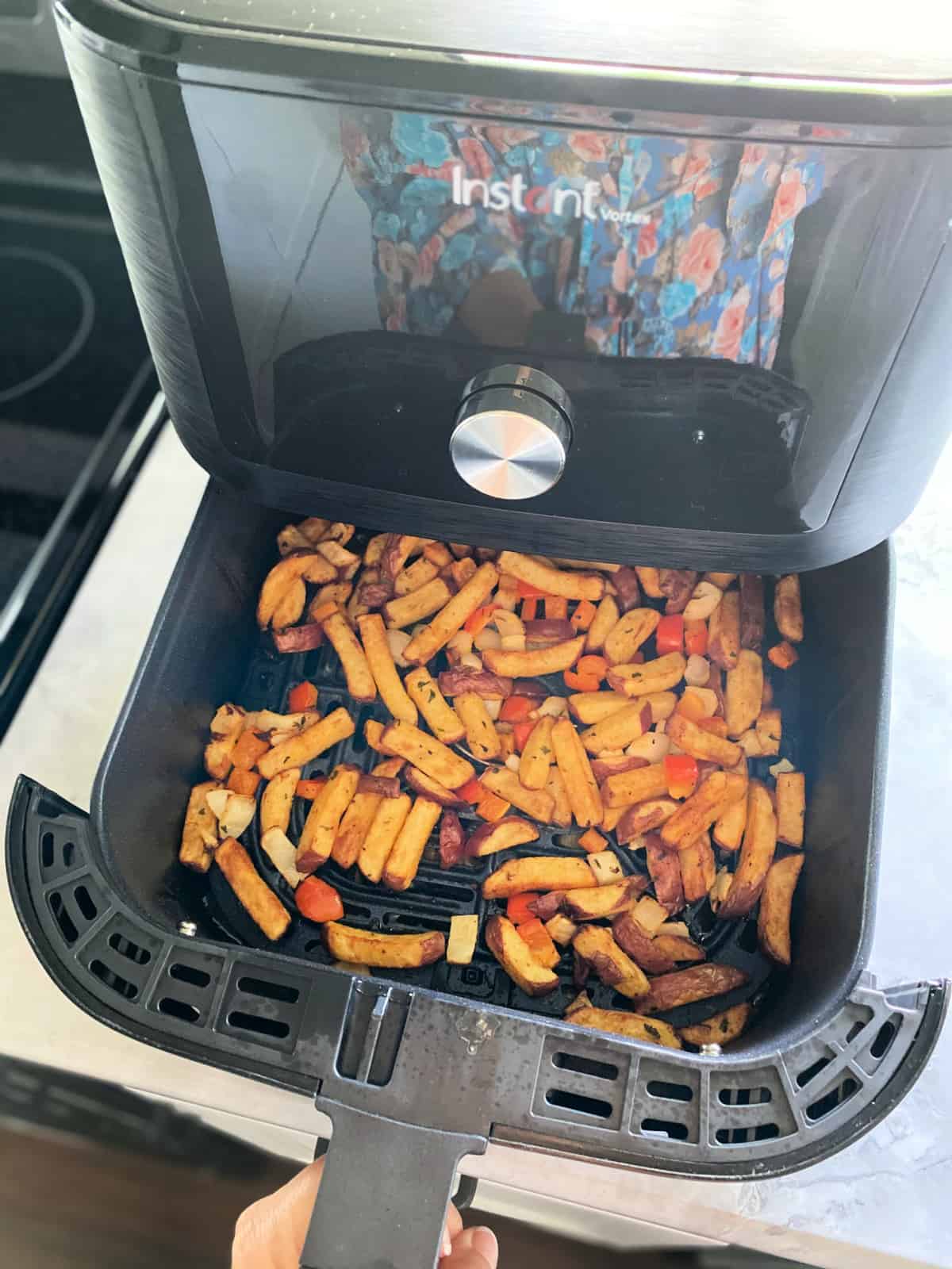 Top view of potato slices in air fryer basket
