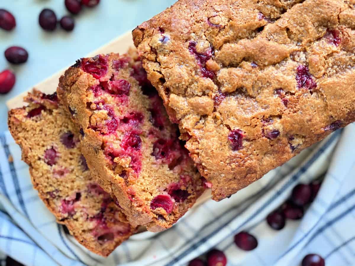 Loaf of cranberry bread with two slices cut.